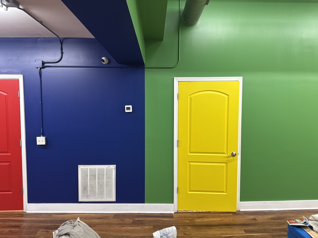 Blue and green accent walls with a bright yellow door