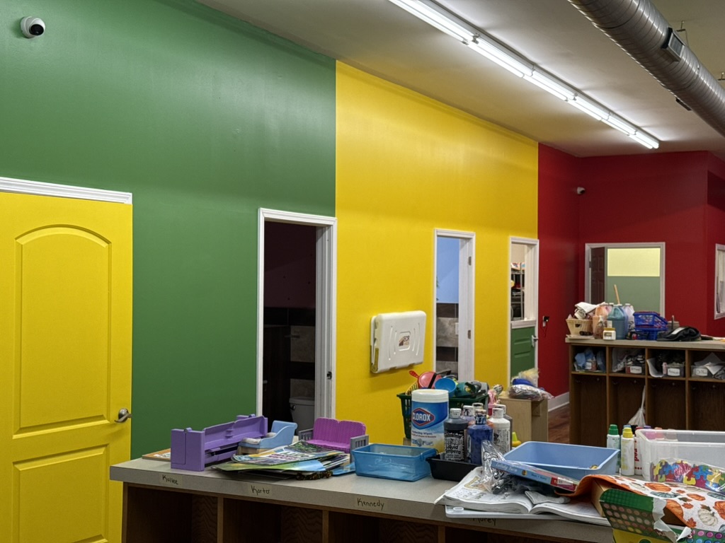 Finished commercial daycare hallway with green, yellow, and red walls