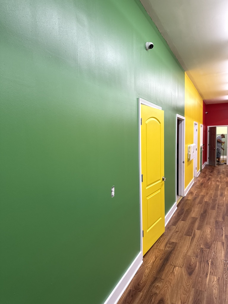 Finished green daycare hallway and yellow door