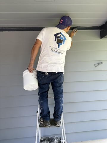 Saint Charles exterior repaint, In progress · Detailed brushwork beneath the porch roof