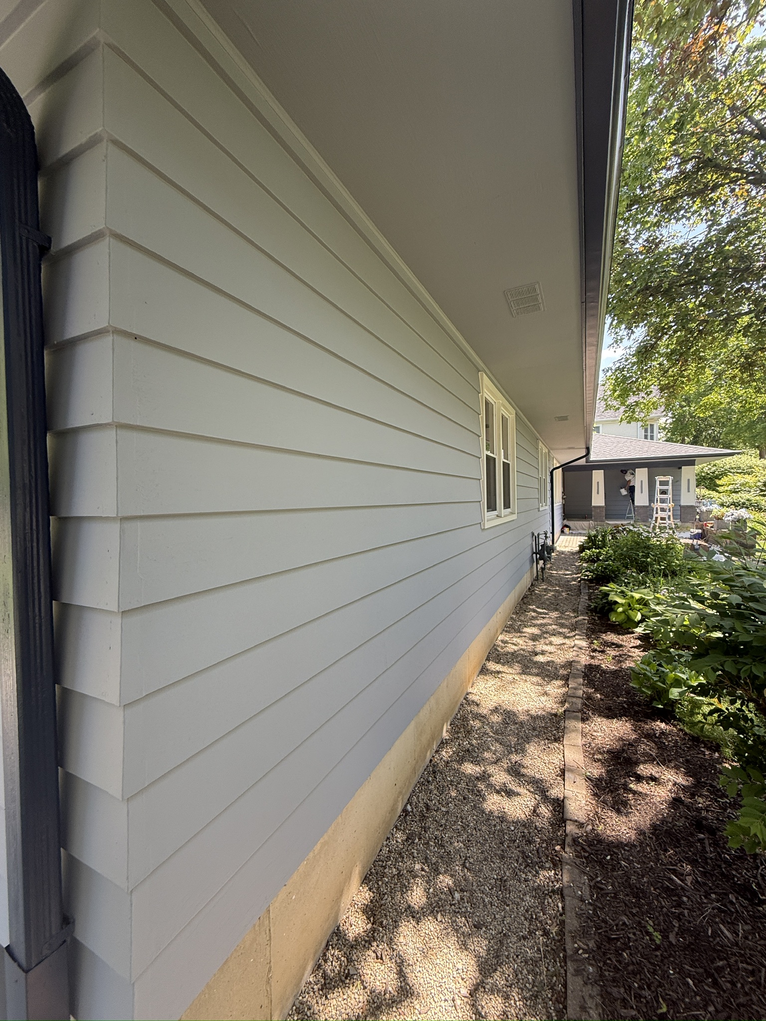 Saint Charles exterior repaint, In progress · Side elevation with porch work underway